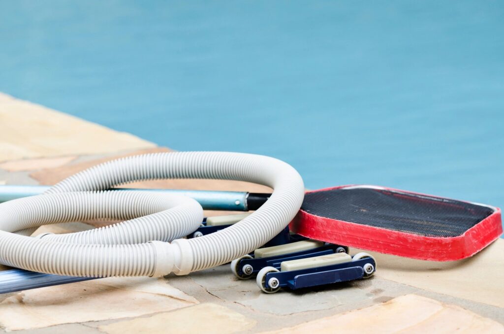 Pool Cleaning Equipment lays next to clean pool in Round Rock, TX